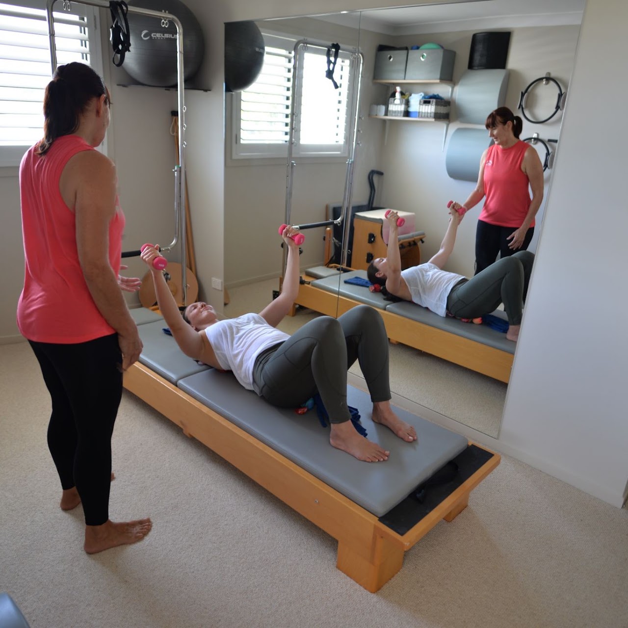 Pilates teacher and client using hand weights on Pilates Half Trapeze Kingsliff